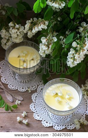 Panna Cotta With Robinia Flavor, Served With Honey And White Robinia Flowers. Rustic Style.