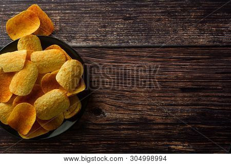 Potato Chips Over Wooden Background. Salty Crispy Snack. Isolated Chips.