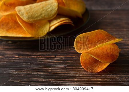 Potato Chips Over Wooden Background. Salty Crispy Snack. Isolated Chips.