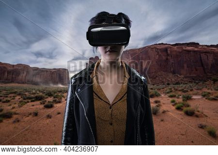 Woman Wearing A Virtual Reality Headset In A Simulated Hiking Experience Through The Desert.  Vr Tou