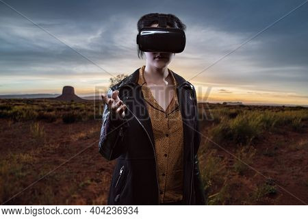 Woman Wearing A Virtual Reality Headset In A Simulated Hiking Experience Through The Desert.  Vr Tou