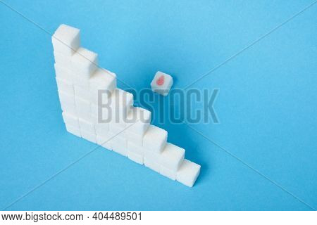 Sugar Cube With A Drawn Drop Of Blood And A Ladder Of Sugar On A Blue Background
