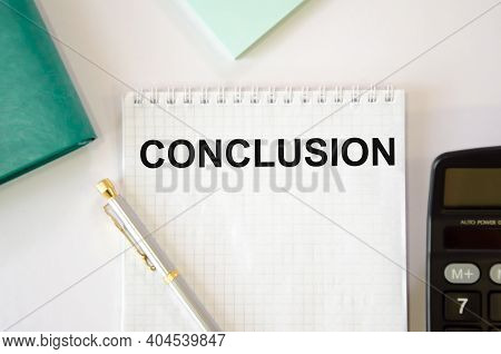 The Word Conclusion Is Written On A White Notepad Which Lies On A White Background Near The Calculat