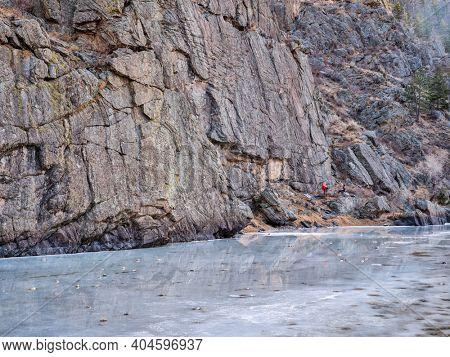 canyon of mountain river in winter scenery with distant rock climbers - Poudre River at Picnic Rock above Fort Collins, Colorado