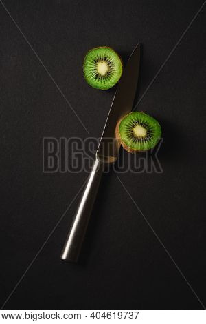 Kiwi Fruits Half Sliced With Kitchen Knife On Dark Background