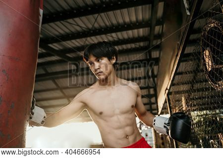 Asian Man Boxer During Boxing Hiting Heavy Bag