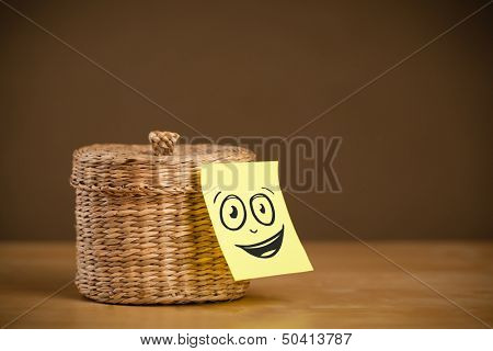 Drawn smiley face on a post-it note sticked on a jewelry box