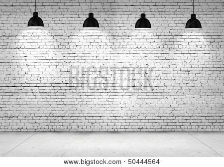 Empty room with blank wall and lamps at ceiling