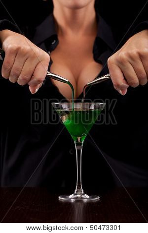Barmaid stands behind bar mixing drink for client