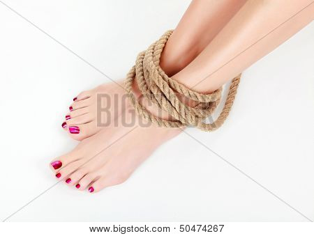 Female legs with thick rope round them 