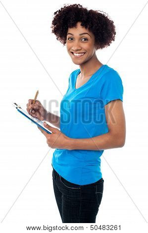 Young Lady Documenting Instructions On Clipboard