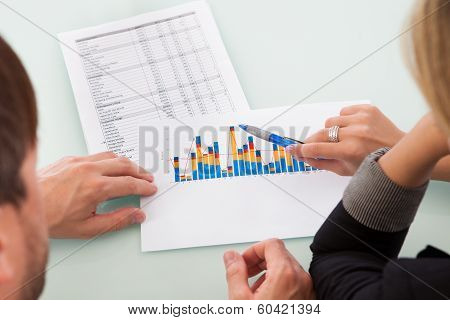 Partners Discussing A Business Graph