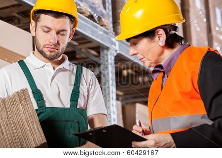 Worker Consulting With Manager In Warehouse