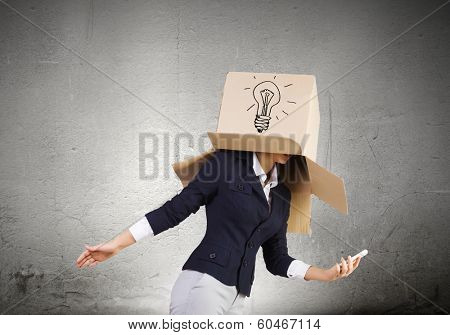 Businesswoman using mobile phone wearing carton box on head
