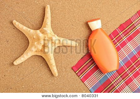 Une vue d'une étoile de mer et de la crème solaire sur une plage