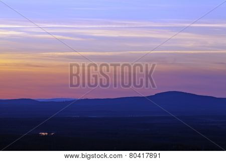 Nightfall up North over forests hills, ridges.