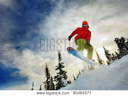 Snowboarder jumping through air with deep blue sky in background