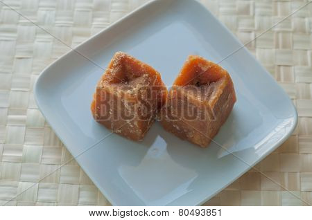 Cane sugar concentrate - an Indian jaggery cakes on white plate