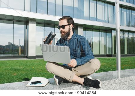 Businessman In Sunglasses With Laptop Drinking Coffee Outdoors