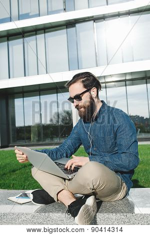 Businessman In Sunglasses With Laptop Outdoors In Front Of Office