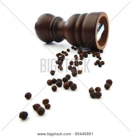 Wooden peppermill with peppercorns isolated on white background