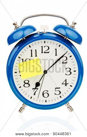 an alarm clock with a sticky note: 