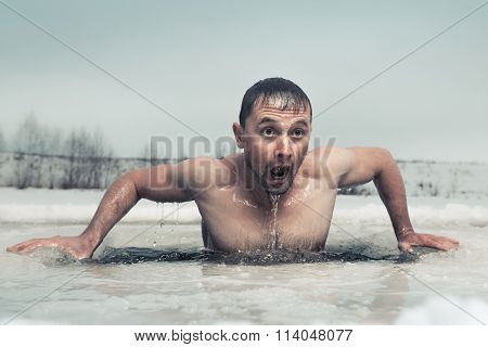 Man swimming in the ice hole with emotional face