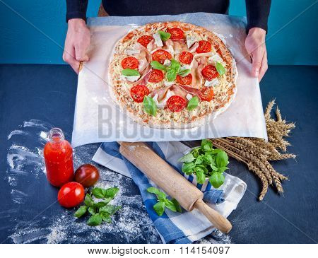 Closeup hand of baker making pizza at kitchen