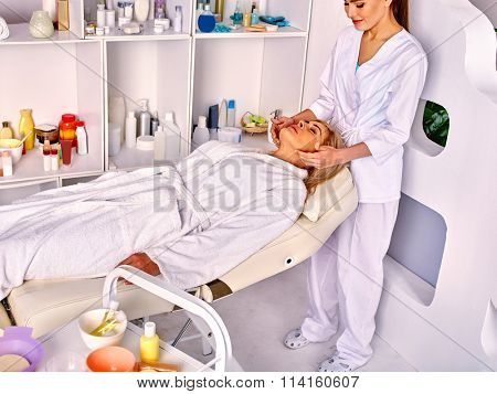 Woman middle-aged in spa salon with beautician.