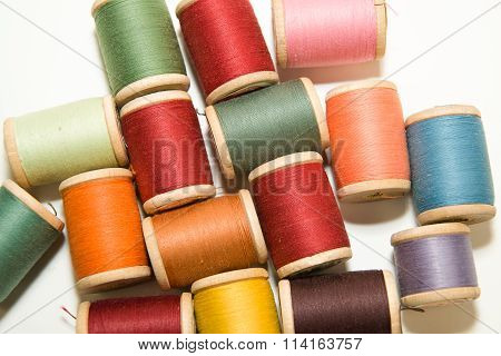 Many Spools Of Thread Of Different Colors On A White