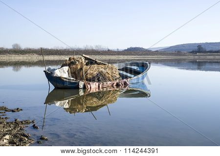 Lonely Fishing Boat In Lake With Reflection