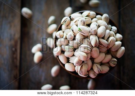 Close-up Of Roasted Pistachios On Wooden Background