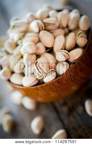Close-up Of Roasted Pistachios On Wooden Background