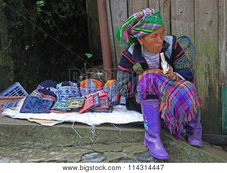 woman in traditional clothes is selling accessories