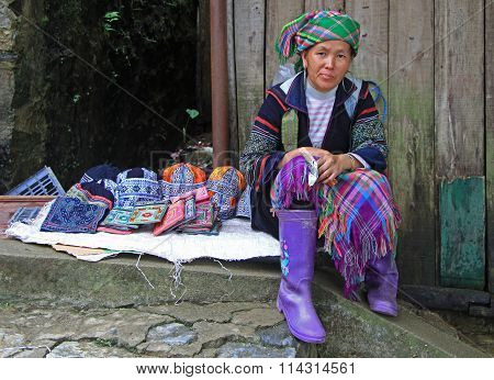 woman in traditional clothes is selling accessories
