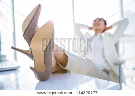 Relaxed businesswoman sitting with her feet up at desk