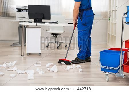 Janitor Sweeping Floor With Broom In Office