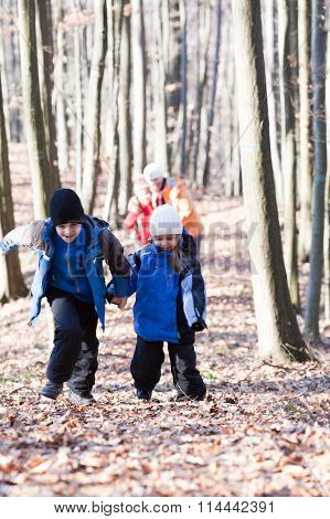 Mother and three children walking in the woods