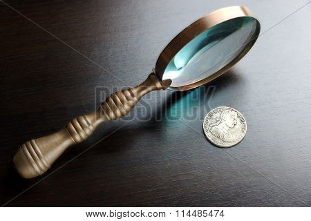 Vintage Magnifying Glass And Old Silver Coins On Black Table