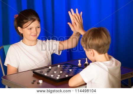 Children Boy And Girl Playing A Board Game Called Checkers