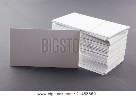 White blank business visit card, gift, ticket, pass, present close up on blurred blue background. Co
