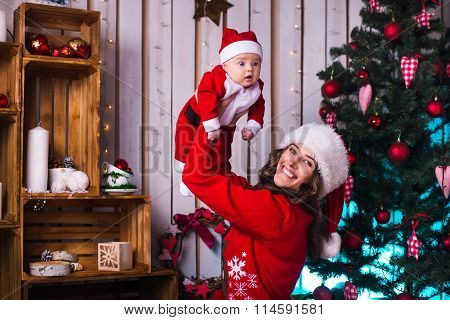 Portrait Of Happy Mother And Adorable Baby In Suit Of Santa's Little Helper