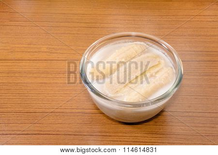 Banana in coconut milk on wooden tableThai traditional dessert