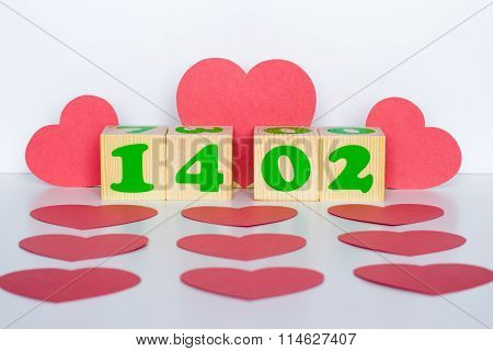 Wood cube with inscription 14 february and red hearts shape