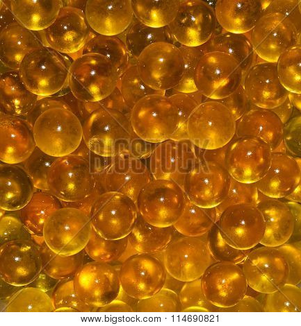 Vertical texture of the round translucent Golden yellow balls. Fish ROE, fish oil. Closeup