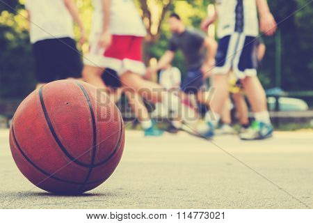Basketball ball detail with de-focused players.