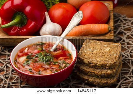 Borscht - traditional russian and ukranian beetroot soup in red bowl on wooden background.