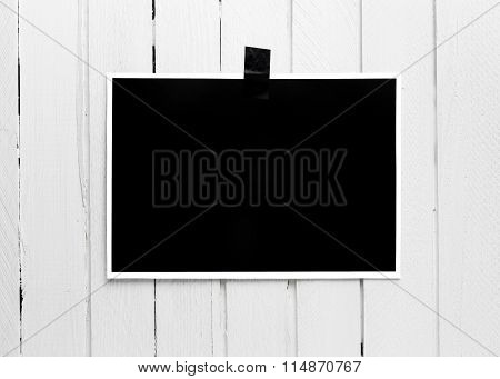 Blank Black Poster Hanging On A Tape On White Wooden Plank Wall.
