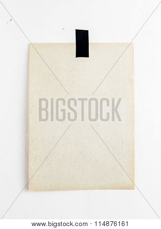 Blank Poster Hanging On A Tape On White Wall. Template Backgroun