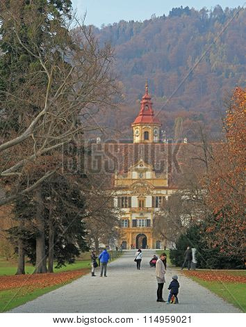people are walking against the background of Eggenberg Palace